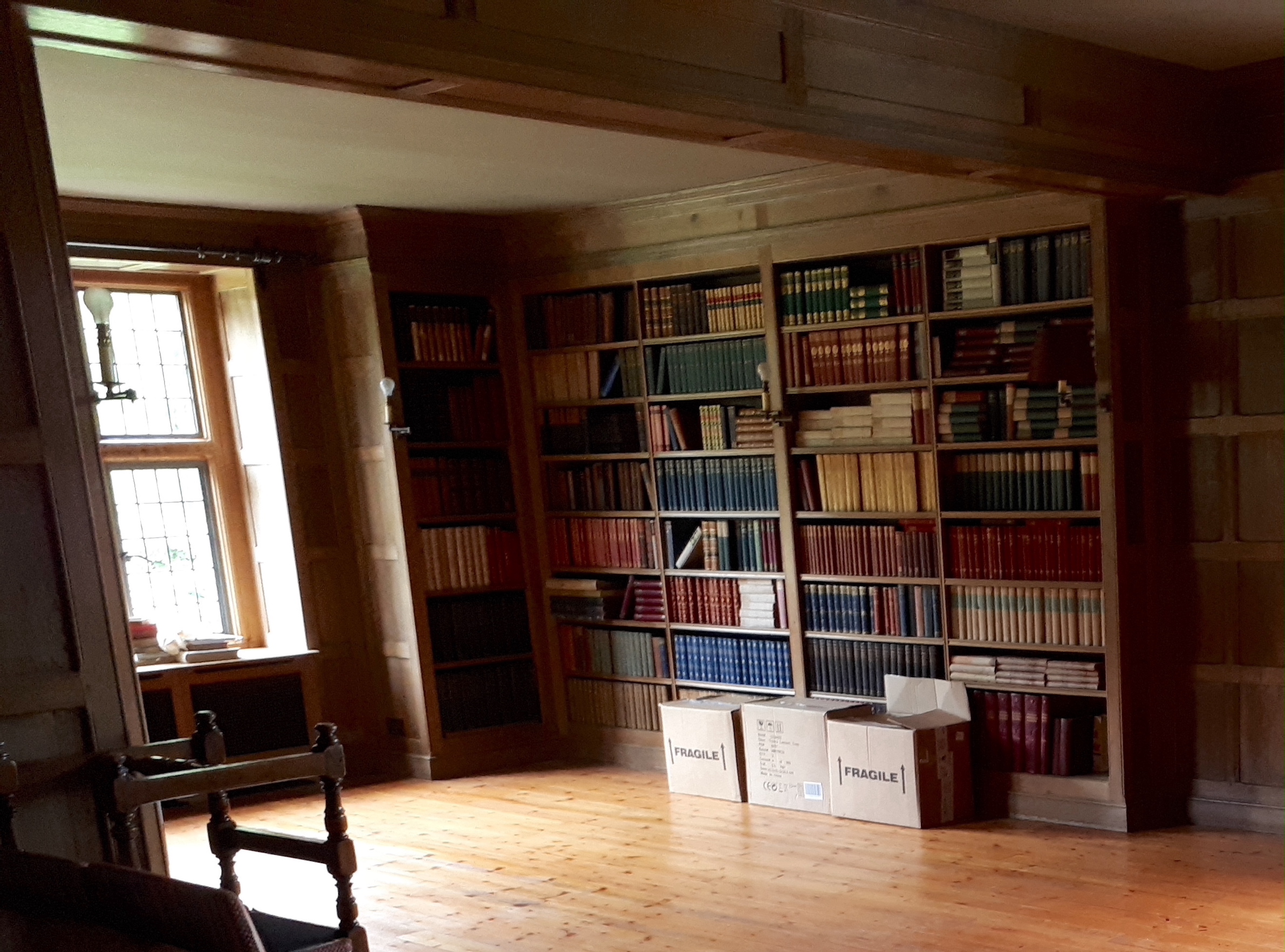 Three dismantled oak bookcases, formerly in the library at Plumpton Place, consisting of an ‘’L’’ shaped section, 455cm, the return 124cm; another ‘’L’’ section, 110cm, the return 68cm, and single section, 255cm, Overall